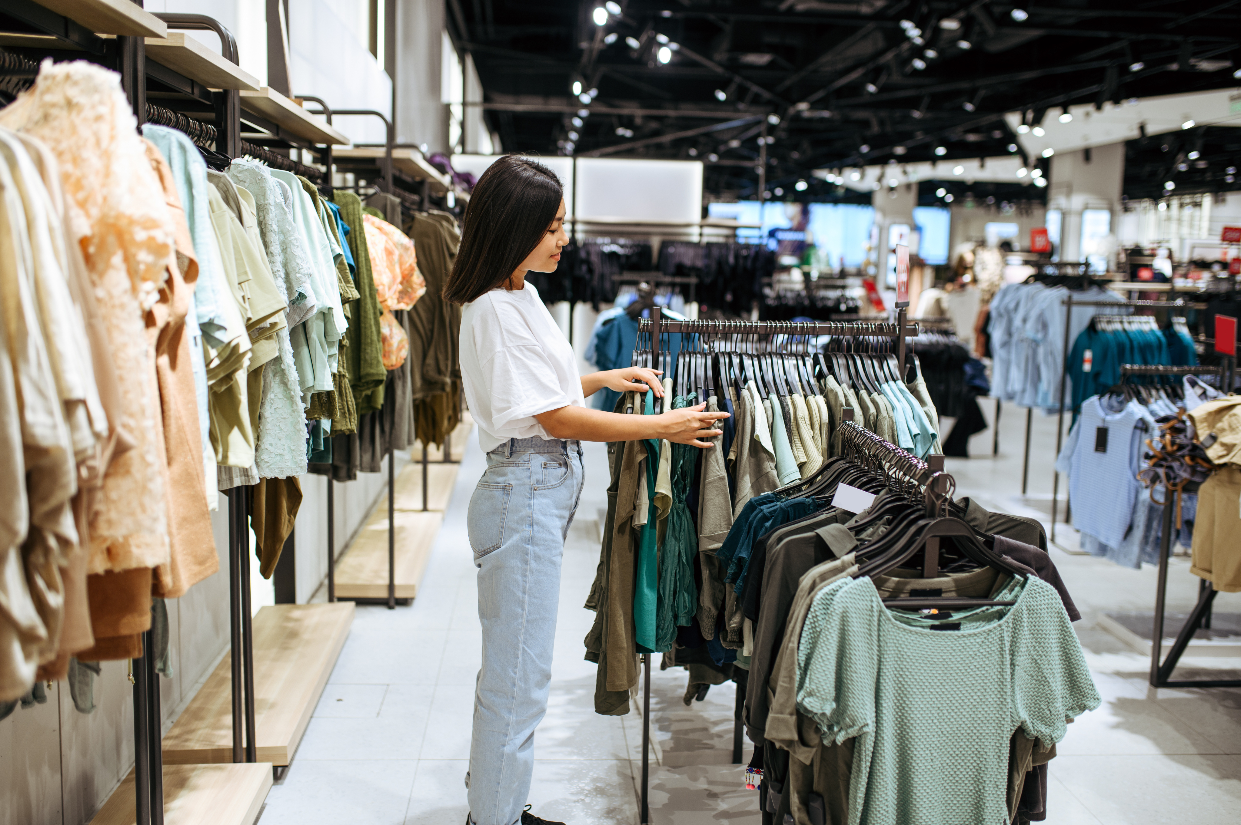 Shopper browsing clothing racks in a retail store