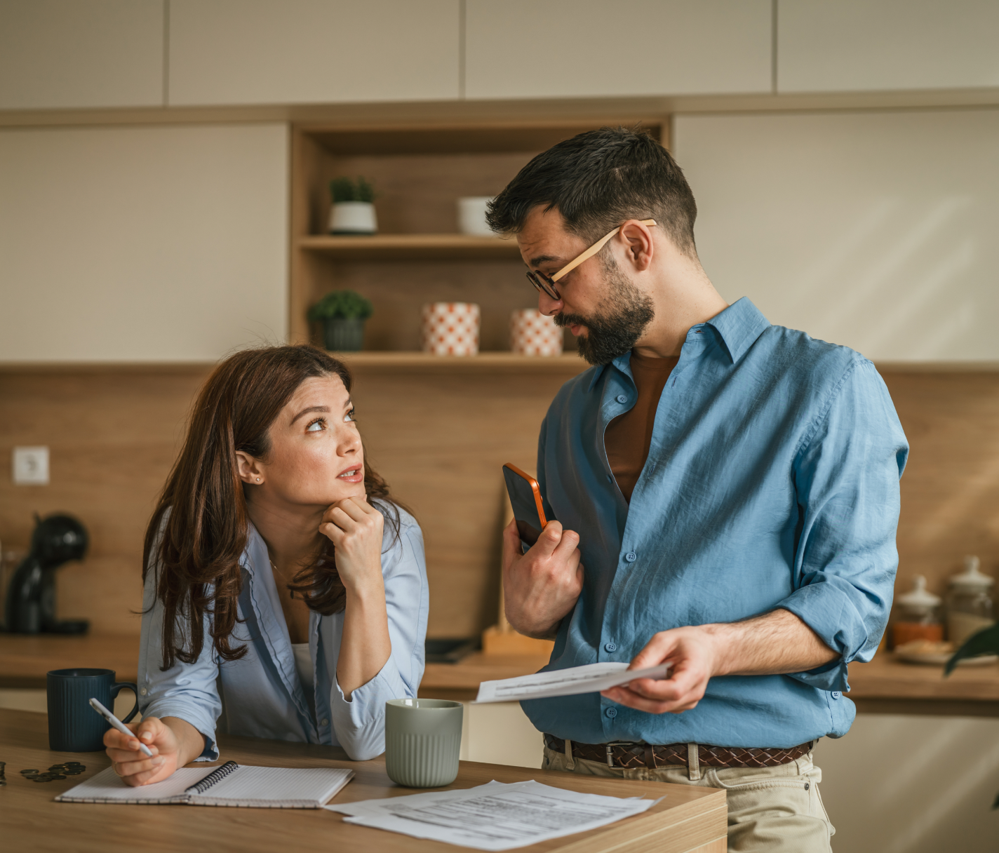 Two people reviewing finances together at a kitchen table